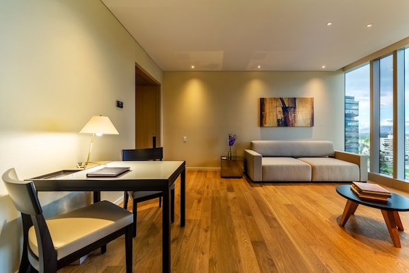A modern living room with a dining area, a sofa, and a coffee table.