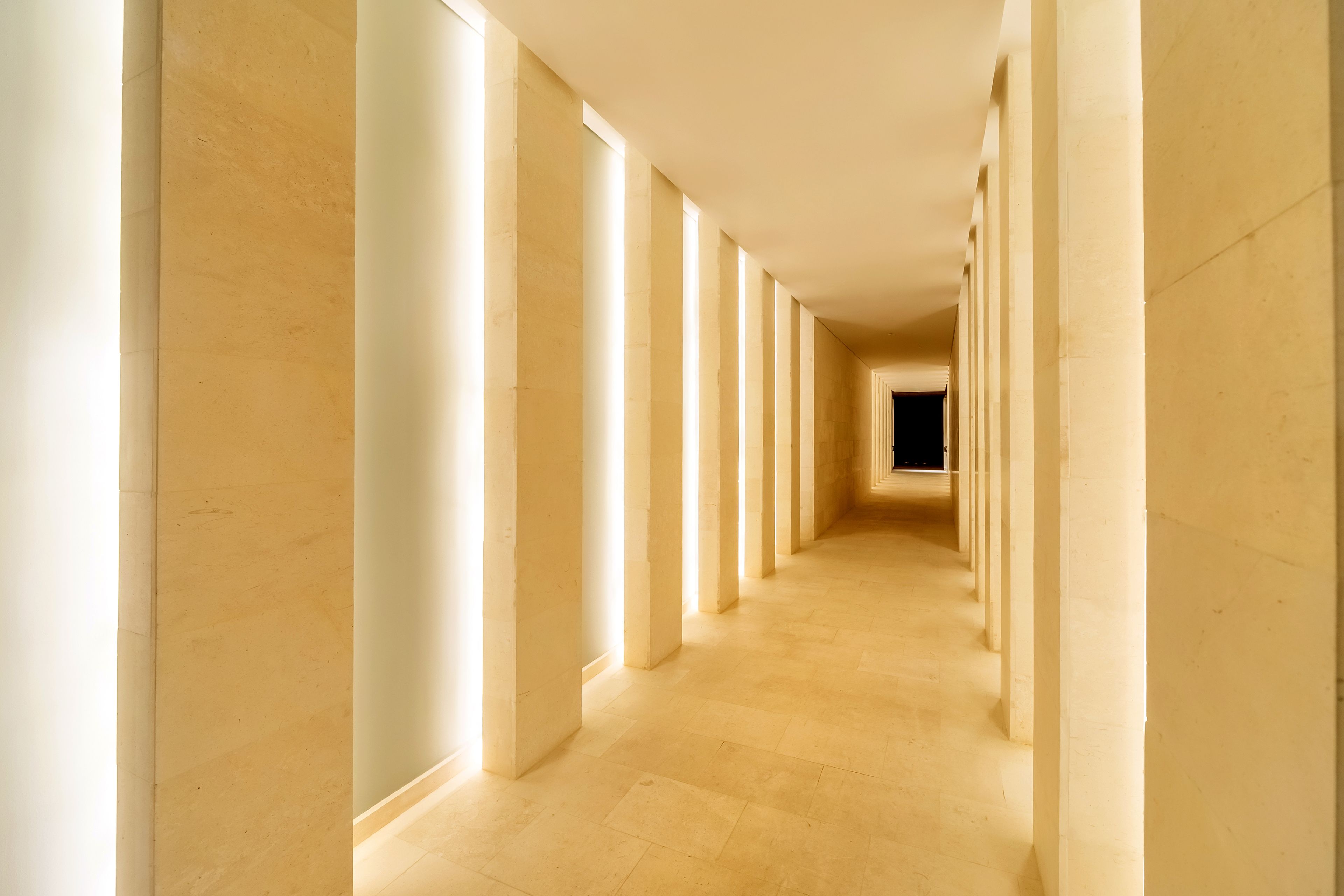 Un long couloir étroit, orné de colonnes régulièrement espacées et doté d’un sol carrelé.