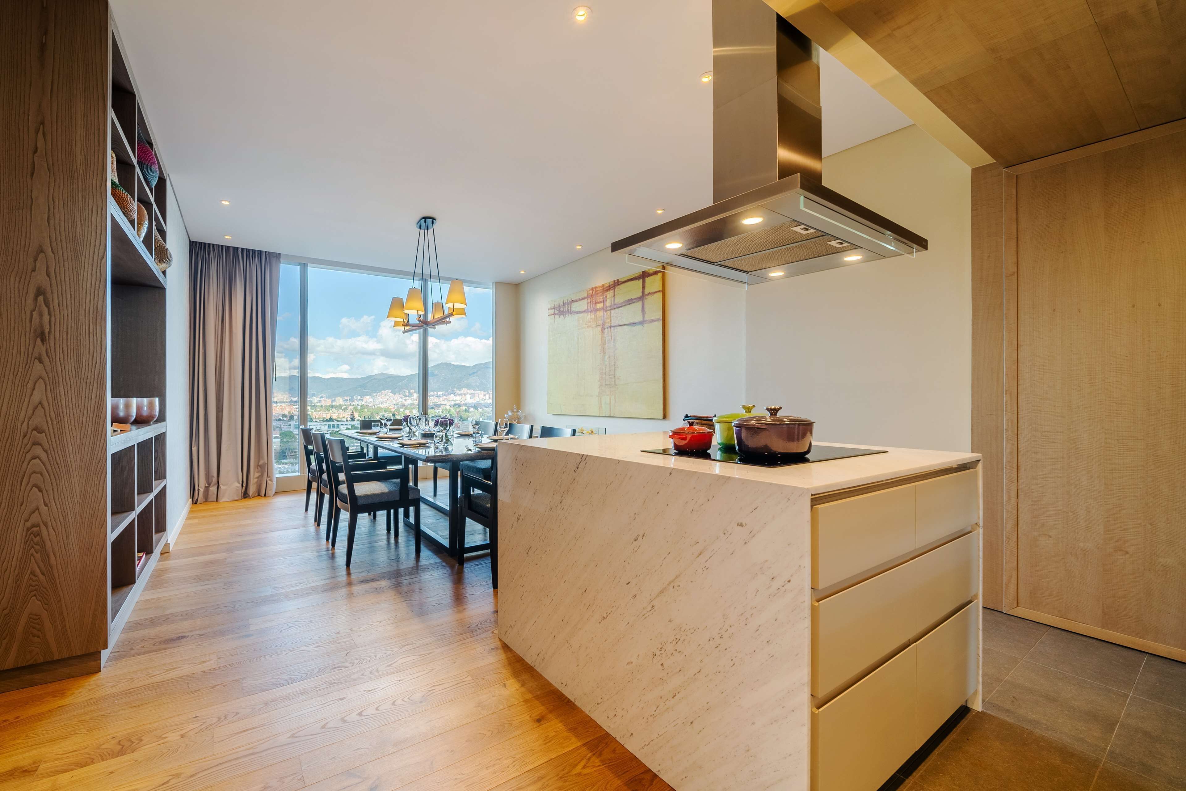 Una cocina moderna con una isla grande, suelo de madera y comedor con vistas.