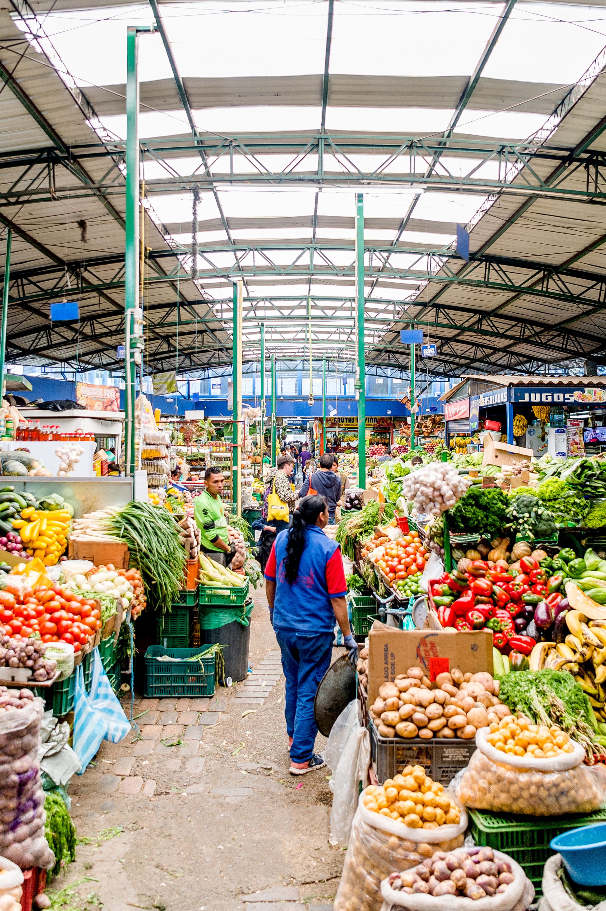 Um mercado com vários quiosques vendendo produtos frescos e mercadorias.