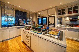 Una cucina moderna con isola centrale, elettrodomestici integrati e vista dalle finestre.