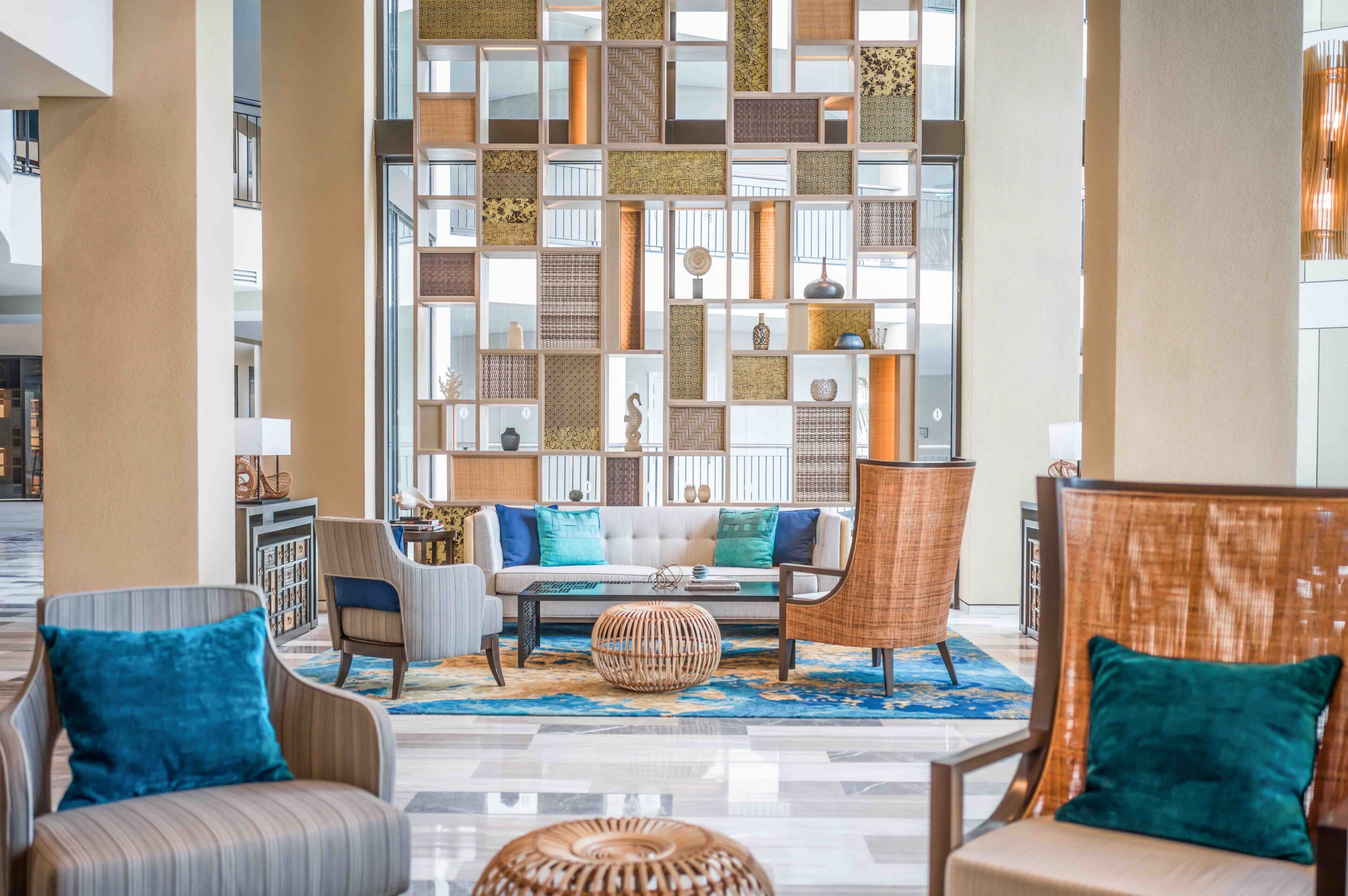 A modern lobby with a seating area, a patterned wall, and a view of the outside.