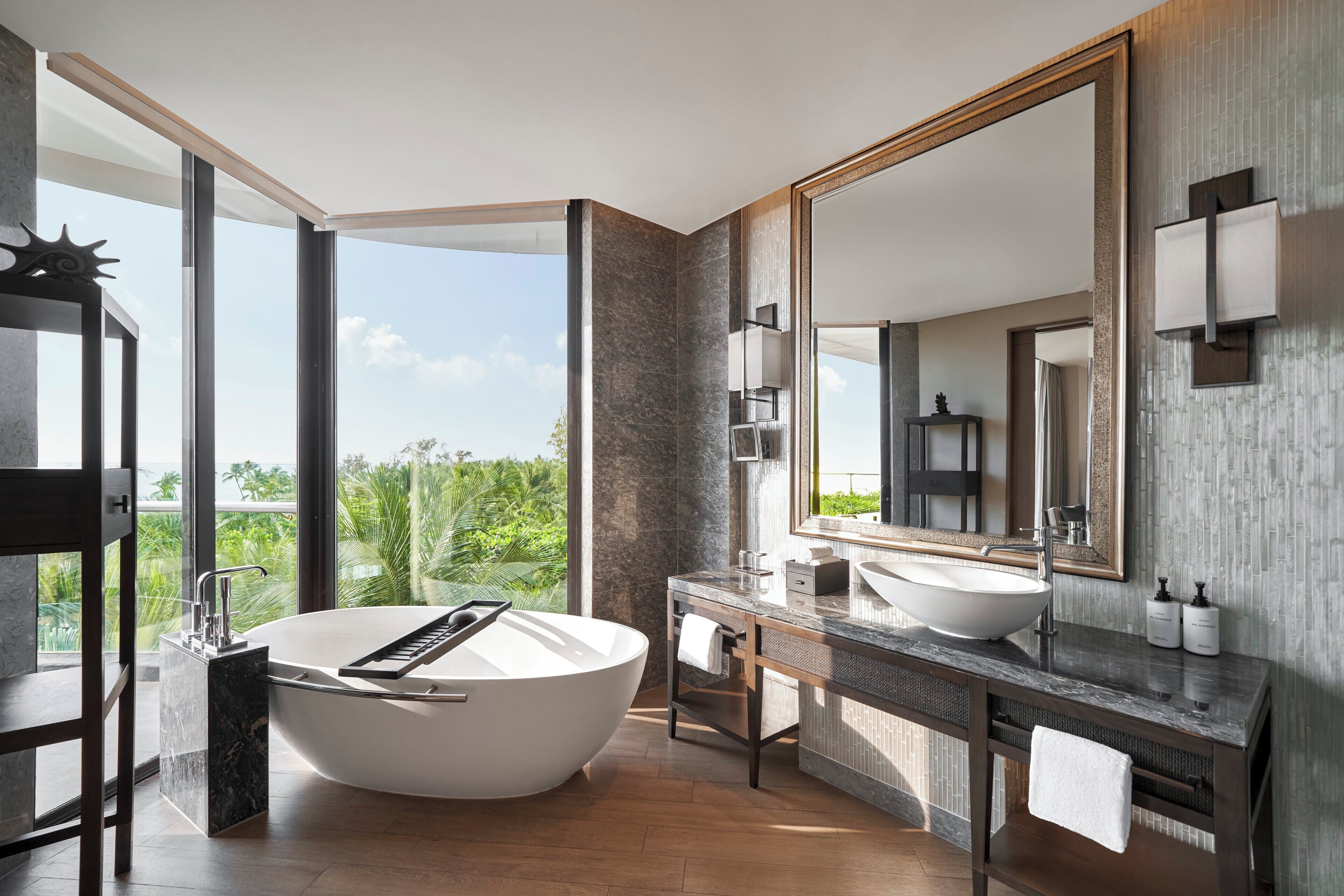 A modern bathroom with a freestanding bathtub, a large mirror, and a vanity with a sink.
