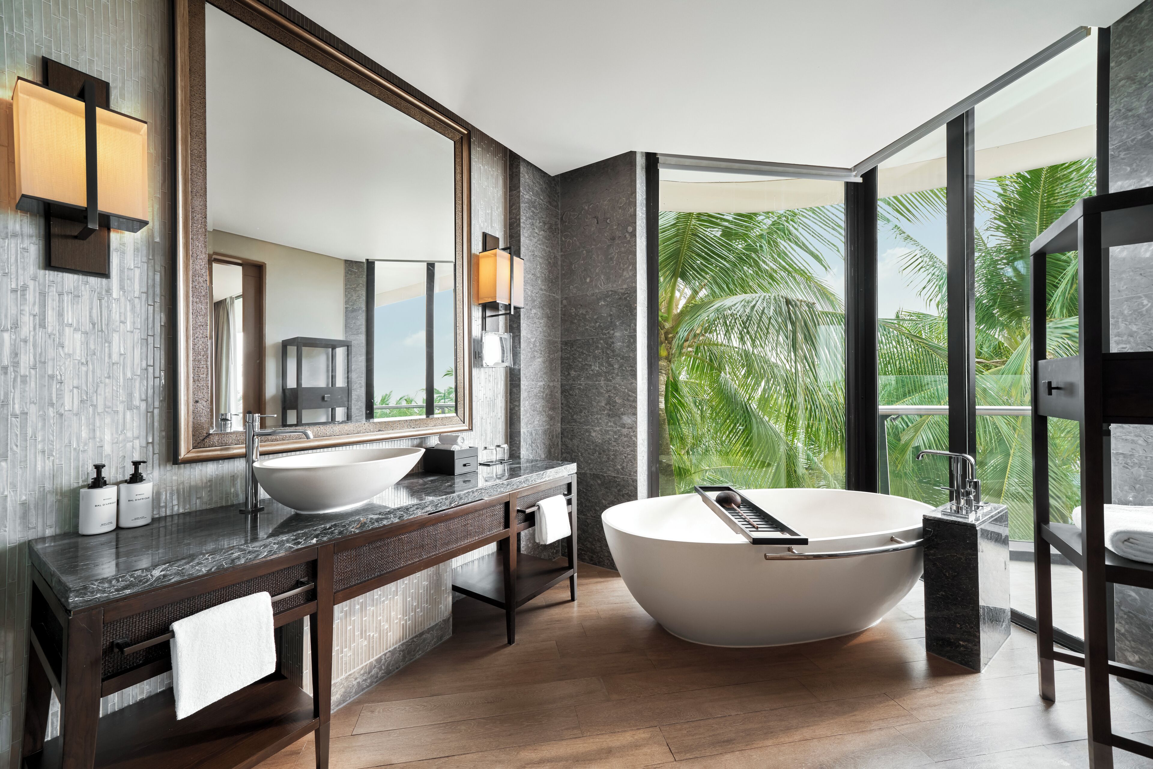 Ein modernes Badezimmer mit einer großzügigen, freistehenden Badewanne, einem Doppelwaschtisch und einem großen Spiegel.