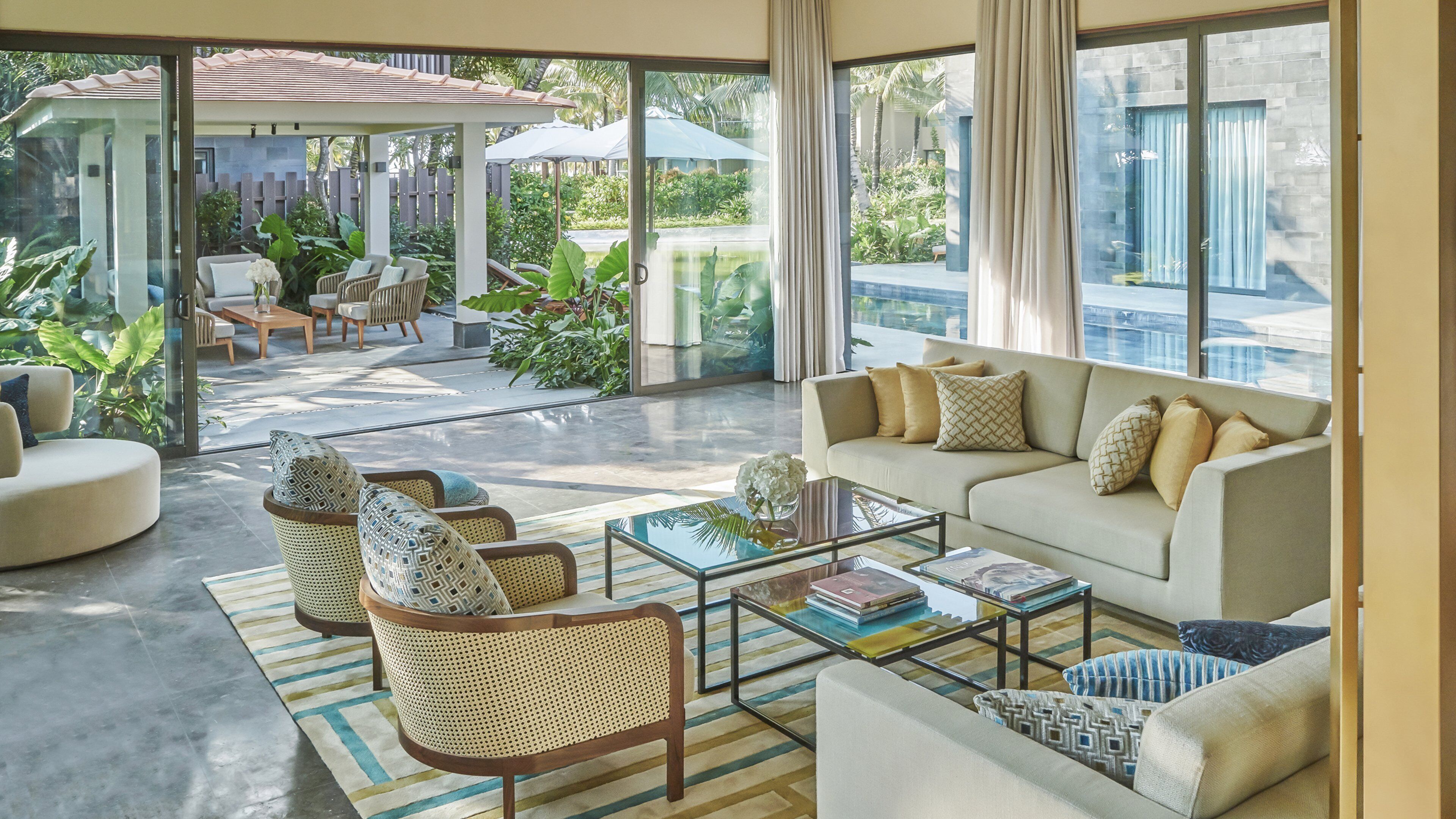 A spacious living area with a sofa, armchairs, and a coffee table.