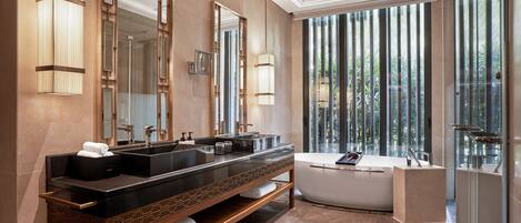 A modern bathroom with two sinks, a bathtub, and large mirrors.