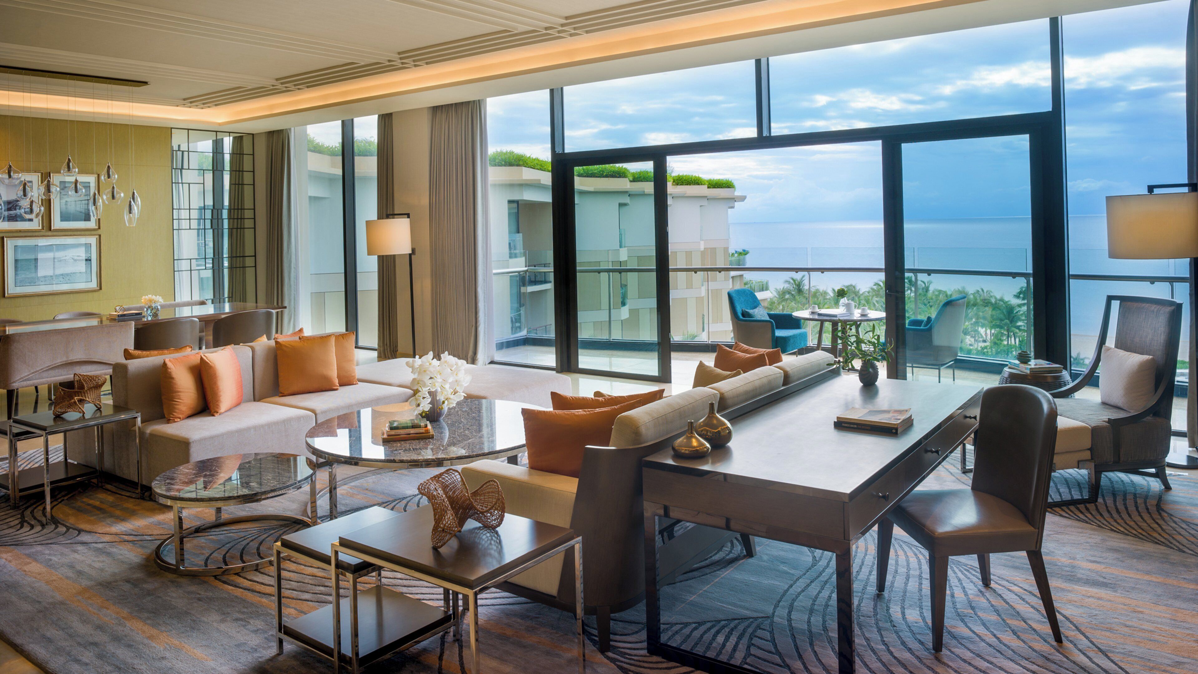 Une chambre d’hôtel spacieuse avec balcon, de grandes fenêtres et un mobilier moderne.