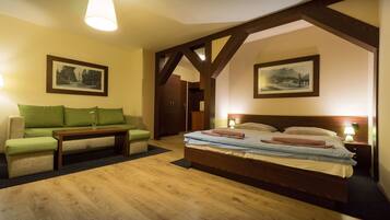 Ein Schlafzimmer mit einem hölzernen Bett, einem grünen Sofa und zwei gerahmten Bildern an den Wänden.