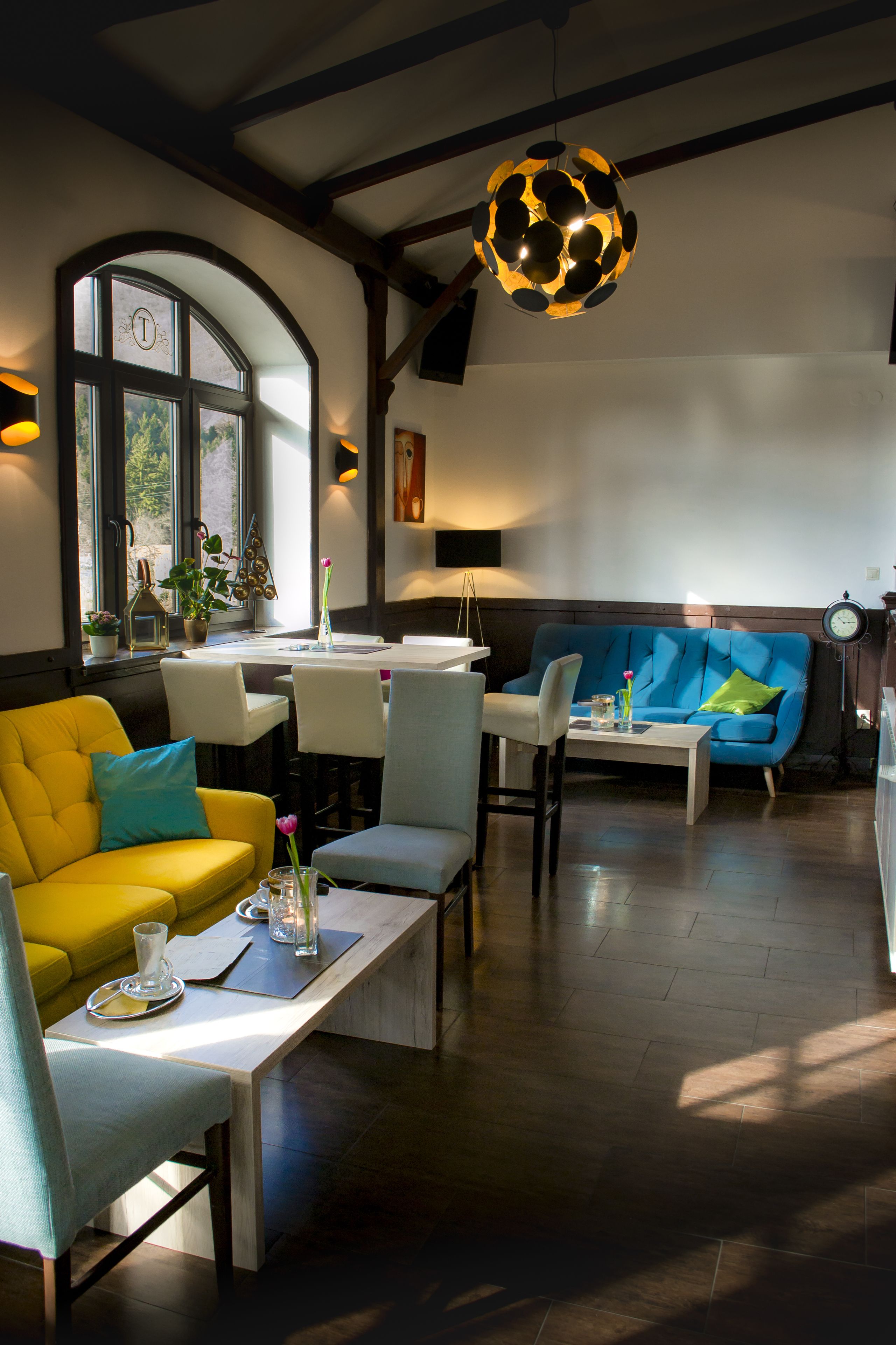 Una sala de estar moderna con un sofá amarillo, un sofá azul y un comedor con una mesa y sillas.