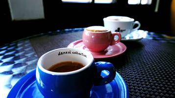 A table with two cups of coffee, one blue and one pink, on a blue saucer.