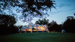 A large, multi-story house with a well-maintained lawn in front.