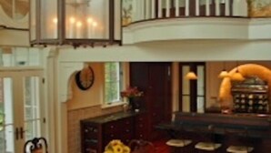 A dining area with a wooden table, chairs, and a chandelier.