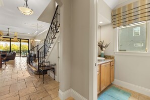 Un intérieur moderne comprenant un escalier, un coin repas et une cuisine.