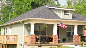 A two-story house with a front porch, a small deck, and an American flag. - Kathy's Kottage. Bungalow on the side of Missionary Ridge, Furry Friends Welcome (Chattanooga)