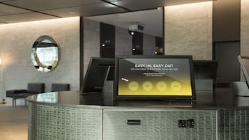 A self-service kiosk with a sign that reads "EASY IN, EASY OUT" and options for selecting languages.