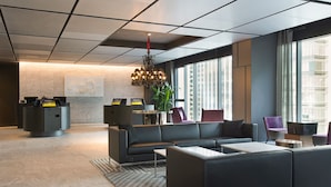 A modern lobby with a reception desk, seating area, and large windows. - L7 GANGNAM by LOTTE HOTELS (Seoul)