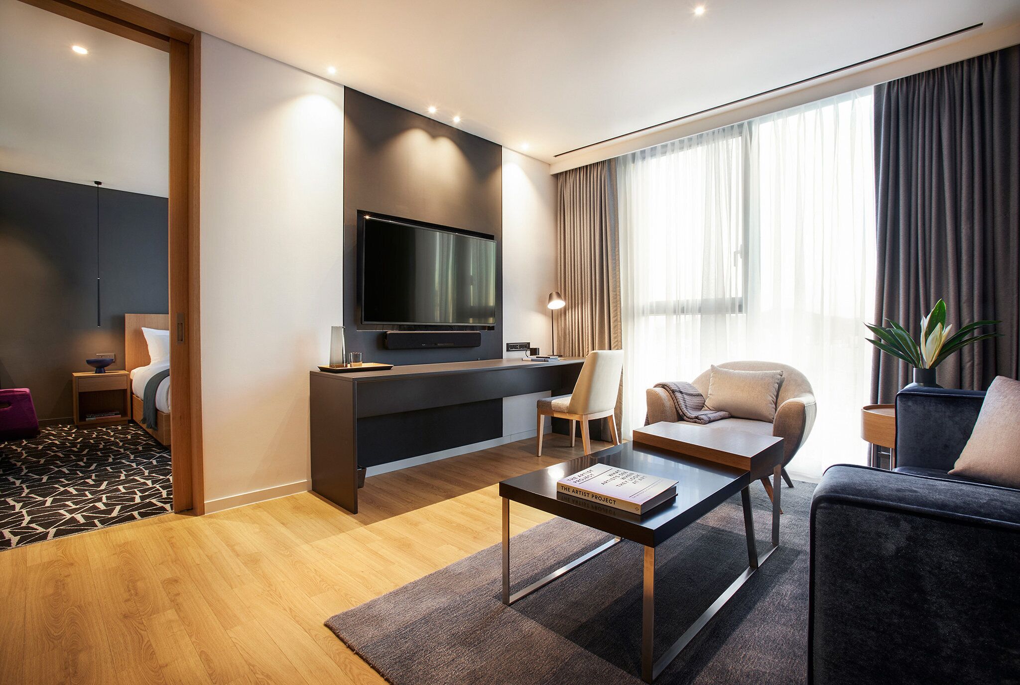 Una sala de estar moderna con televisión de pantalla plana, un sofá, una mesa de centro y un espacio de escritorio.
