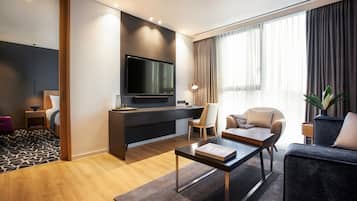 Una sala de estar moderna con televisión de pantalla plana, un sofá, una mesa de centro y un espacio de escritorio.