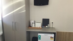A hotel room with a minibar, a coffee maker, a toaster, and a flat-screen TV on the wall. - Northside Hotel Albury (Lavington)