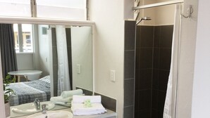 A bathroom with two sinks, a mirror, a shower, and a towel rack. - Northside Hotel Albury (Lavington)