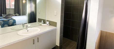 Kamer, 1 queensize bed, privébadkamer | Badkamer | Een douche, gratis toiletartikelen, handdoeken