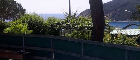 A swimming pool with a view of the sea and hills in the background.