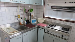 Una cocina pequeña con fregadero, estufa y armarios.