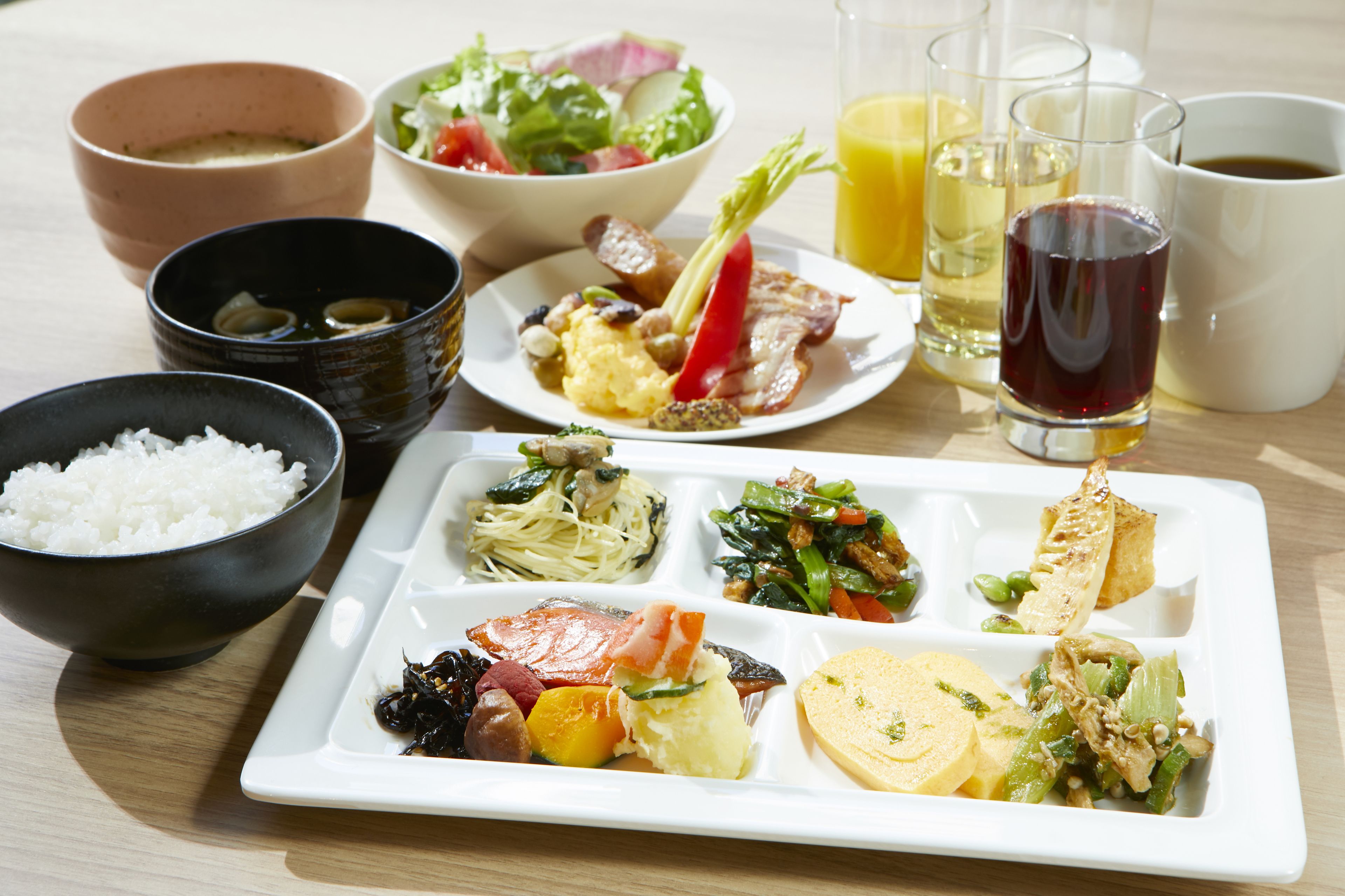 Una comida con diferentes platos y bebidas sobre una mesa.