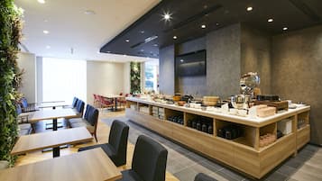 A modern restaurant with a long counter, seating area, and a large window.