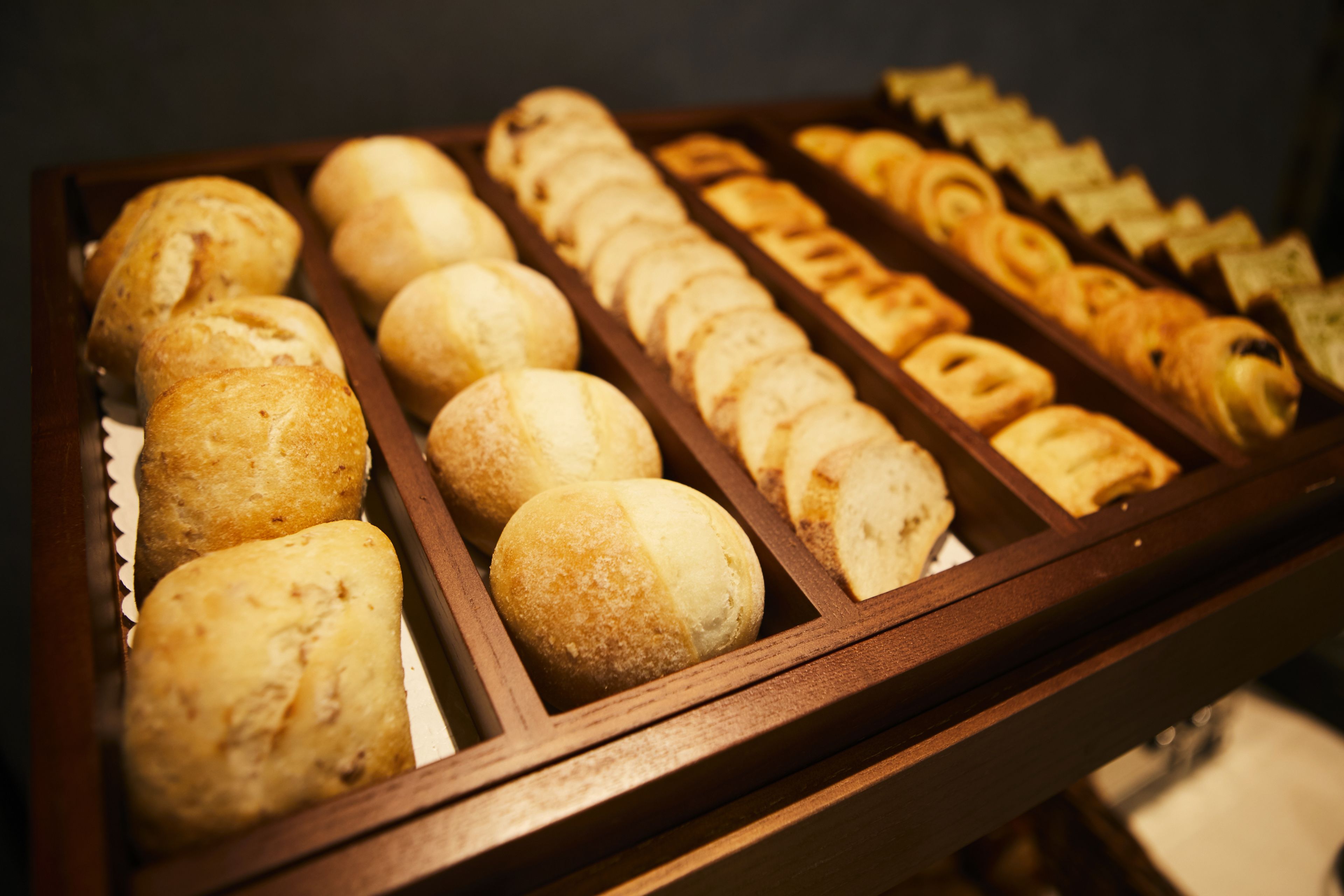 A display case with various baked goods, including bread and pastries.
