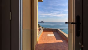 Un balcone con vista sul mare e un'isola in lontananza.