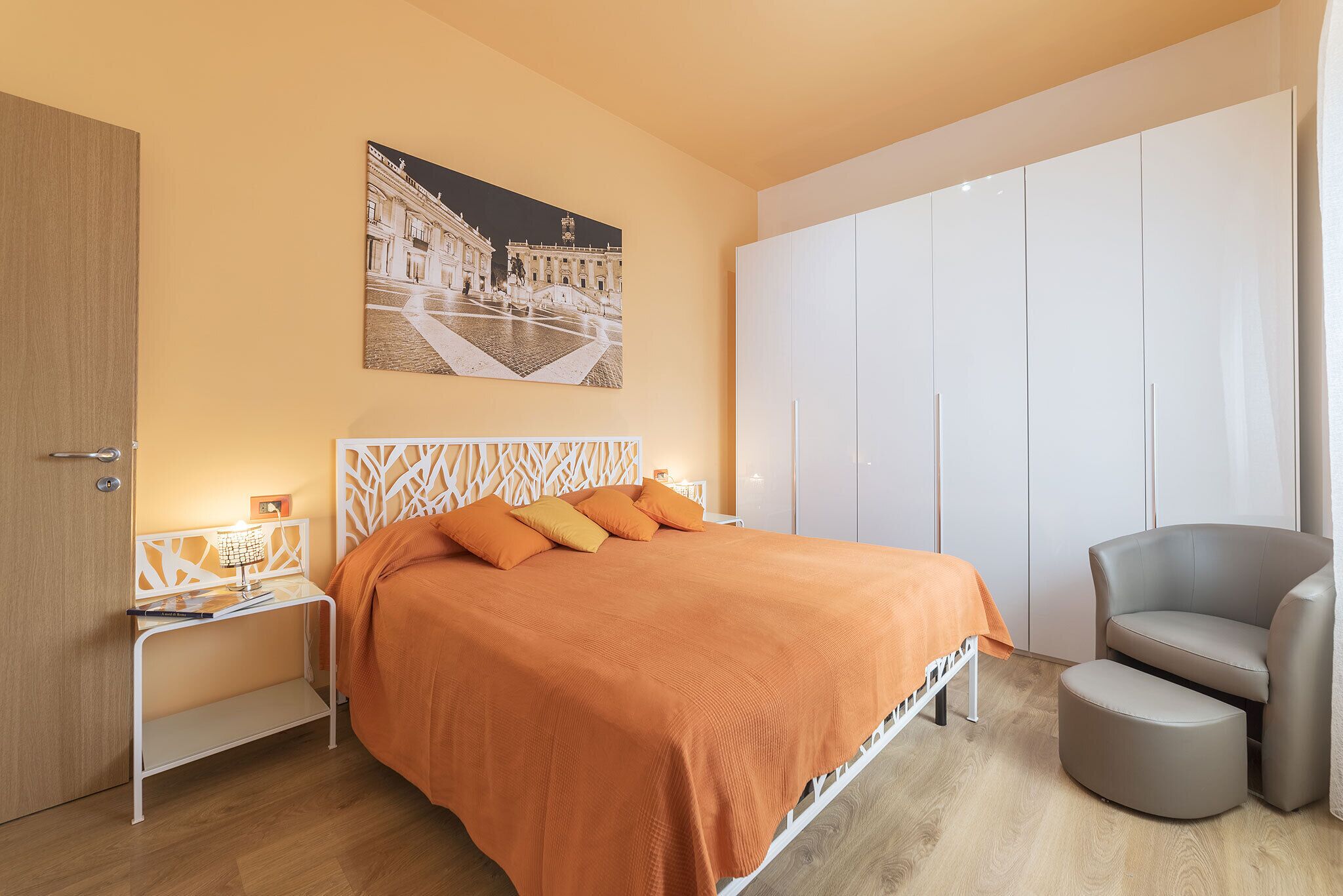 Ein Schlafzimmer mit einem Bett, einem Nachttisch, einem Sessel und einem Kleiderschrank.