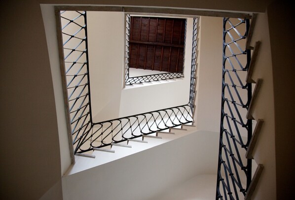 A staircase with metal railings and a small window at the top.