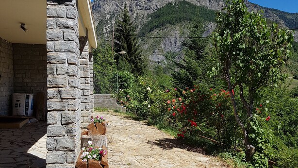 A stone building with a balcony, a stone pathway, and a mountainous backdrop. - Val D'Allos mountain chalet for 8 people (Villars-Colmars)