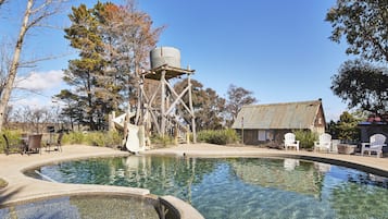 Een buitenzwembad en ligstoelen