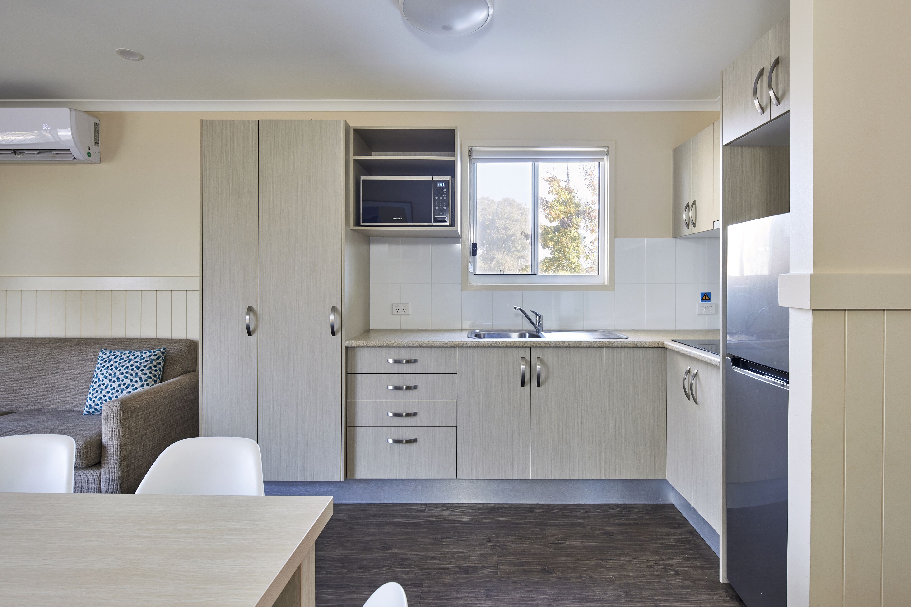 A modern kitchen with a microwave, sink, and stainless steel appliances.