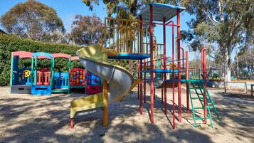 A playground with a slide, climbing structures, and colorful play equipment.