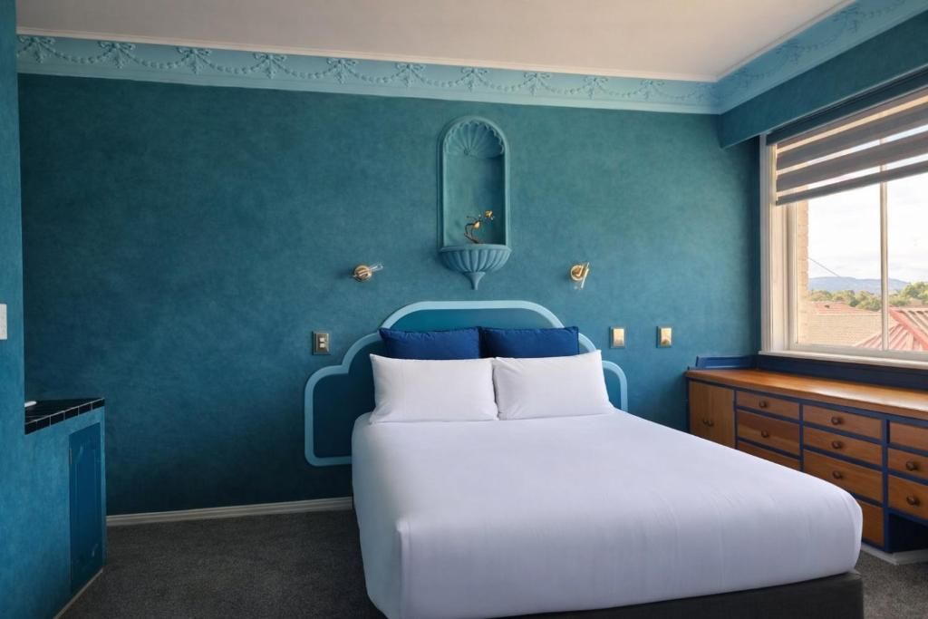 Une chambre à coucher avec un lit, une commode et une fenêtre.