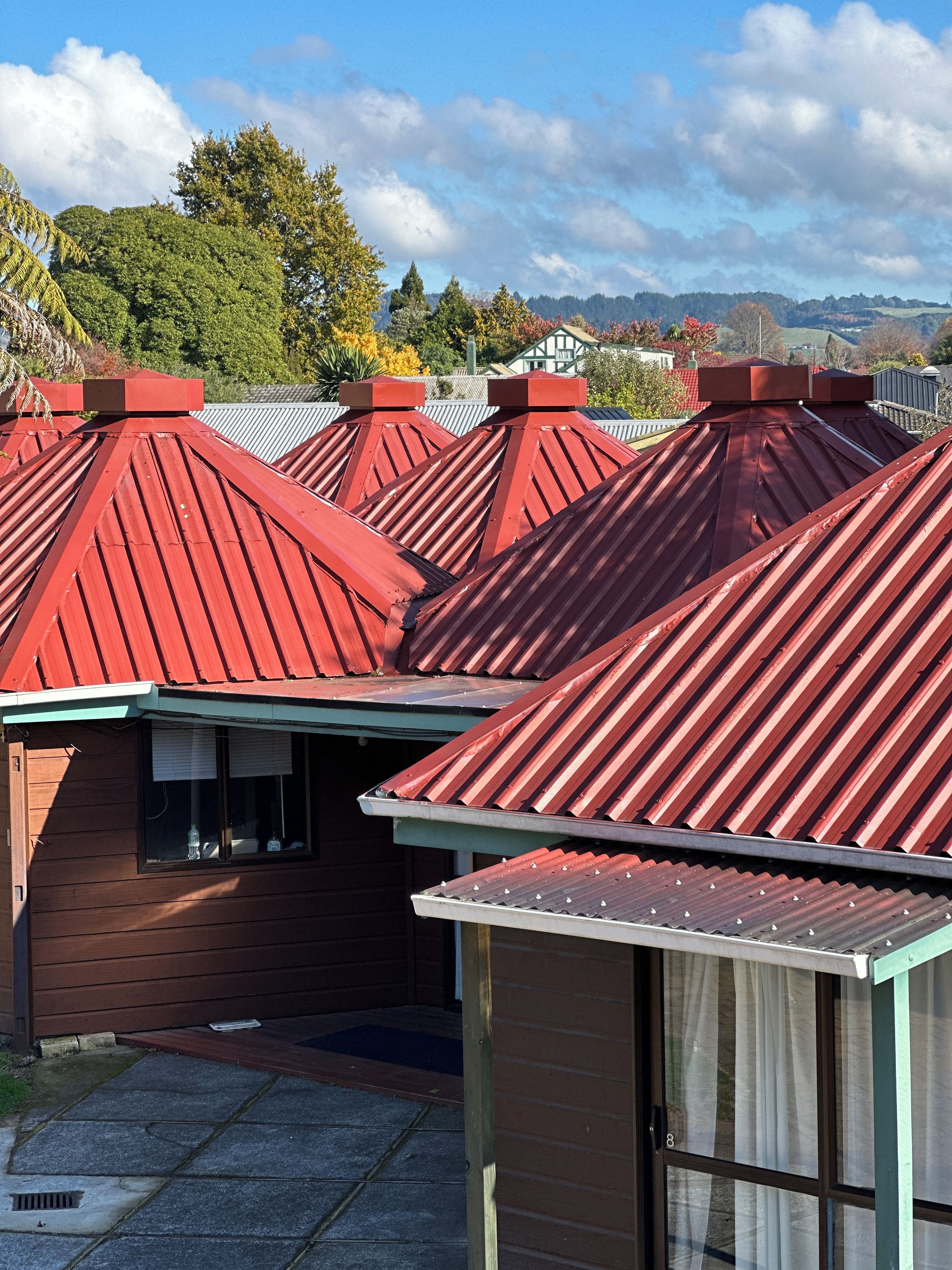 A row of red-roofed cottages with a clear view of the surrounding landscape.