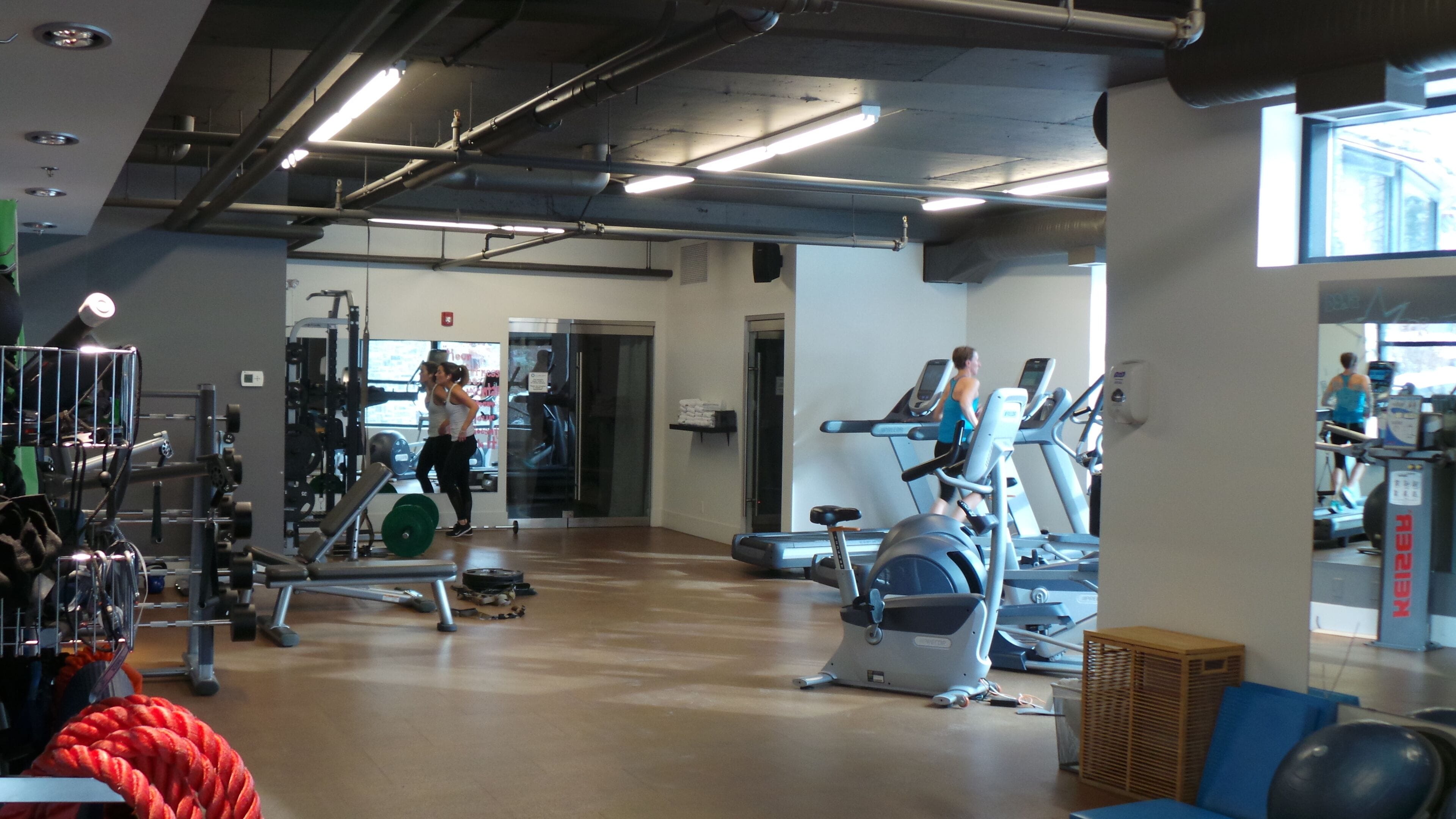 A gym with exercise equipment, a weight rack, and a treadmill.