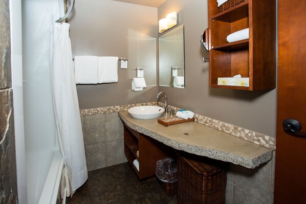 A bathroom with a white sink, a mirror, a towel rack, and a wooden shelf with towels. - FIVE STAR RESORT AND SPA - PET FRIENDLY (Canmore)