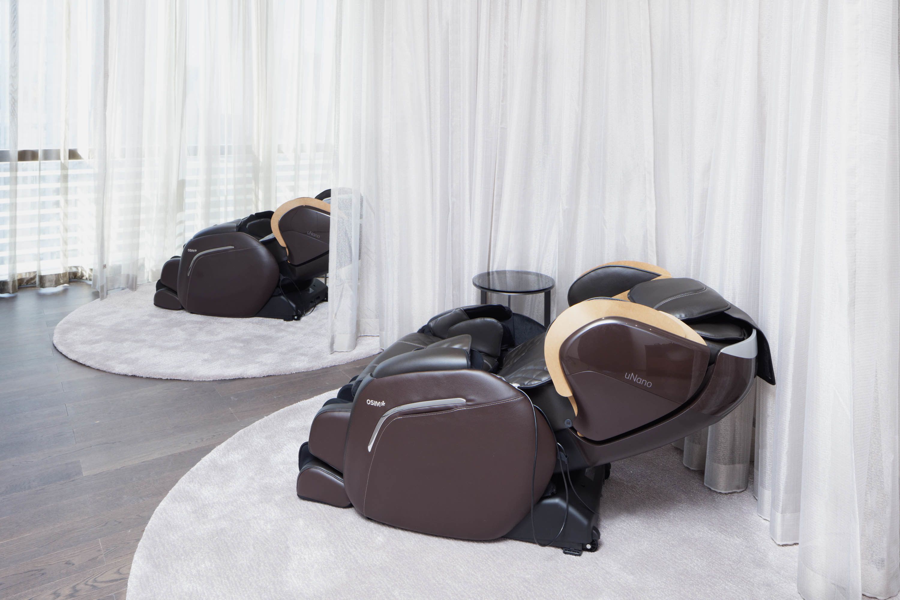 Un espace dédié aux fauteuils de massage, comprenant deux fauteuils et une petite table.