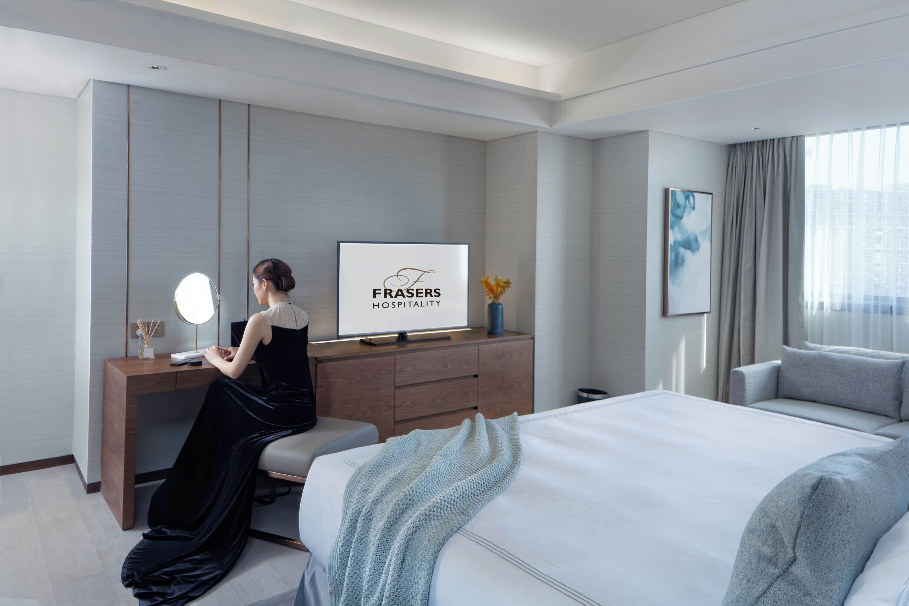Una habitación de hotel con una cama, un escritorio con espejo, un televisor y una ventana con cortinas.