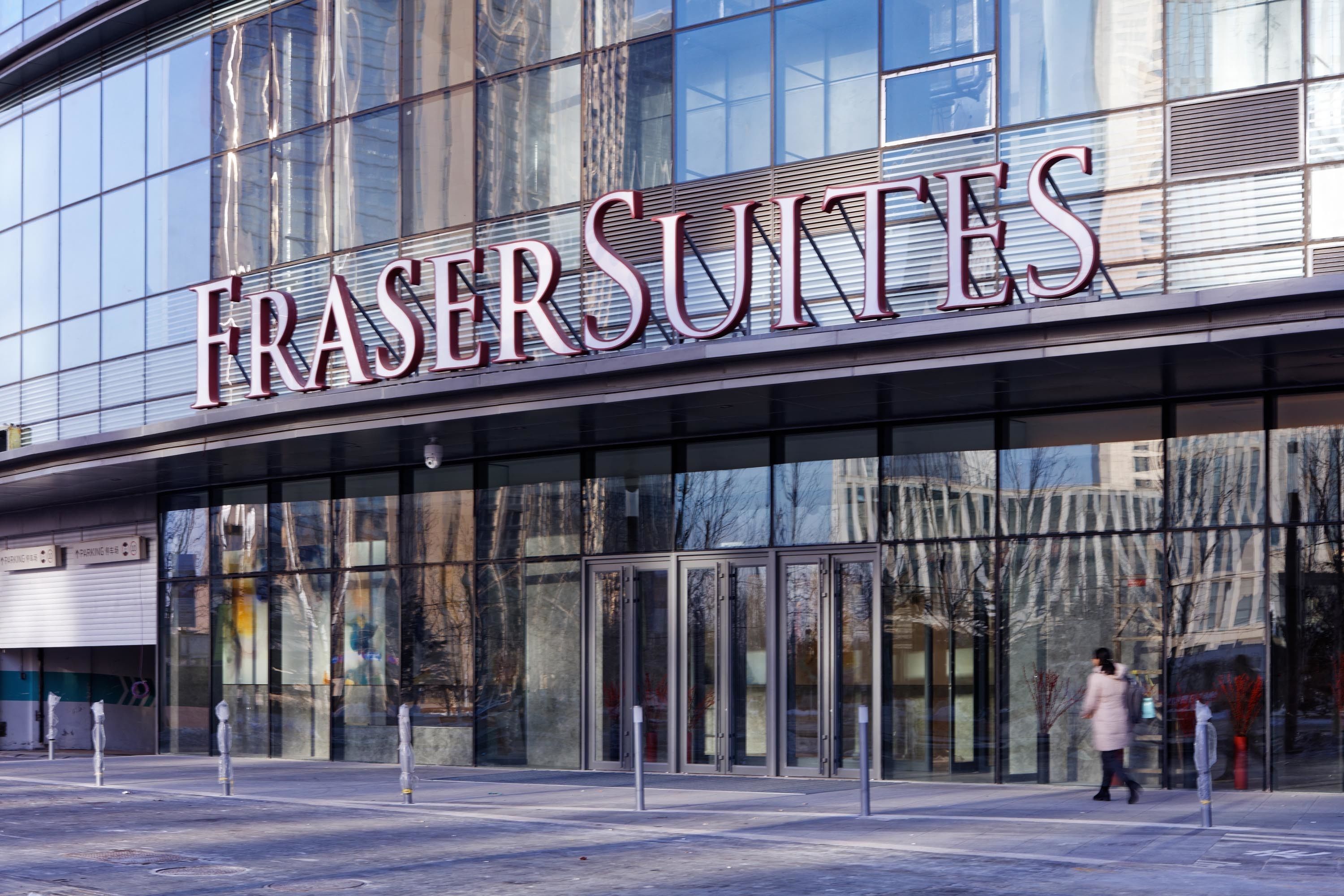 Un edificio moderno con el letrero "FRASER SUNTES", que indica un hotel o establecimiento comercial.