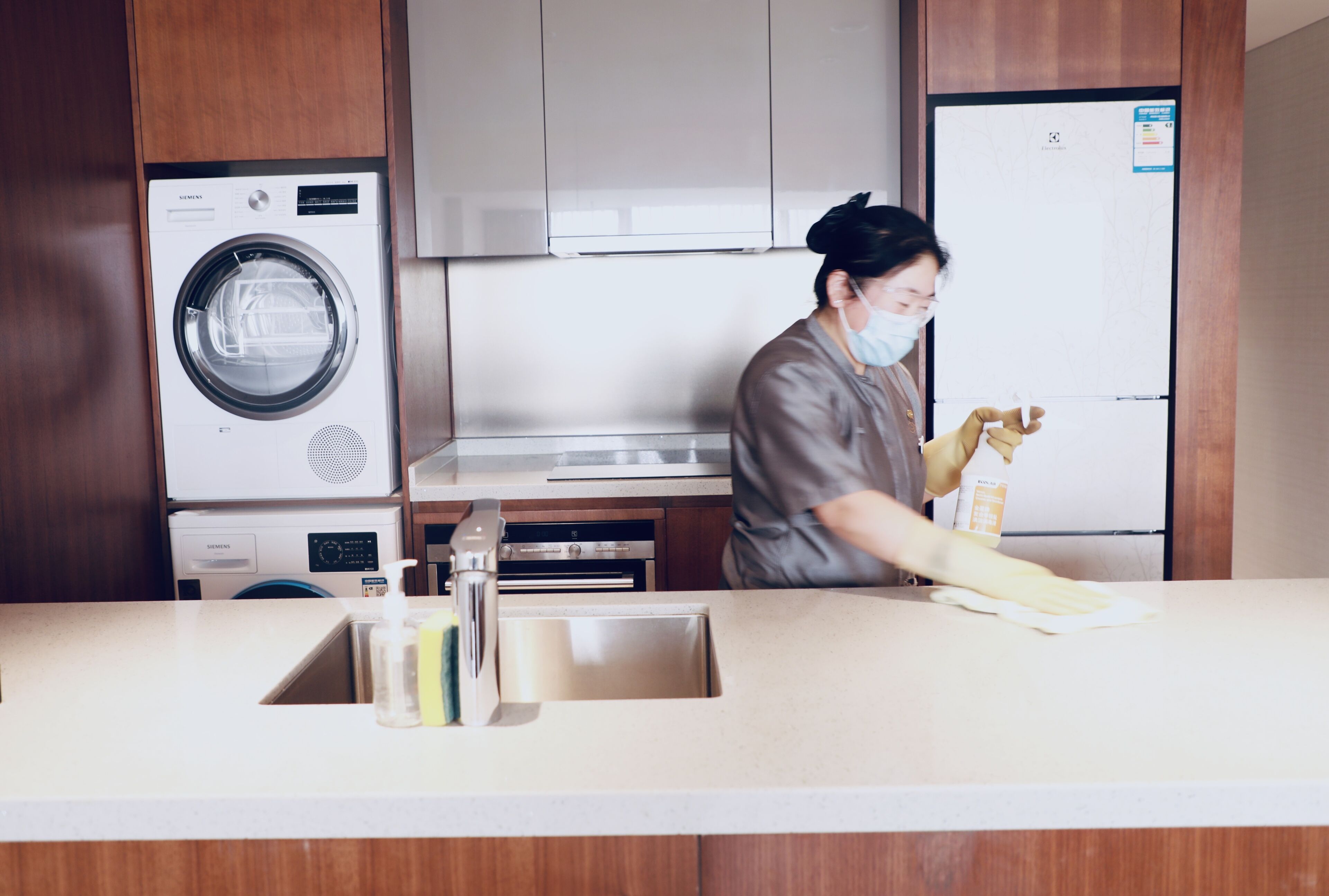 A kitchen with a washing machine, a refrigerator, and a sink.