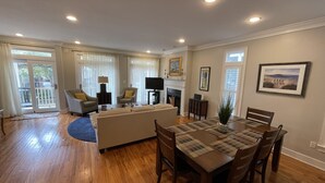 A spacious living room with a sofa, chairs, a dining table, and a fireplace. - Ocean Views, Steps to the Beach & GP Pools, Monthly Long Term discounts (Isle of Palms)