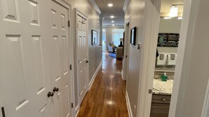 A hallway with wooden flooring, white doors, and recessed ceiling lights. - Ocean Views, Steps to the Beach & GP Pools, Monthly Long Term discounts (Isle of Palms)