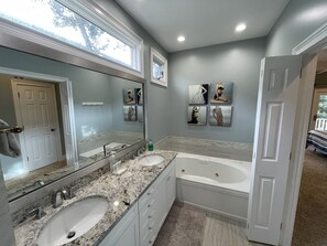A modern bathroom with two sinks, a large mirror, and artwork on the wall. - Ocean Views, Steps to the Beach & GP Pools, Monthly Long Term discounts (Isle of Palms)