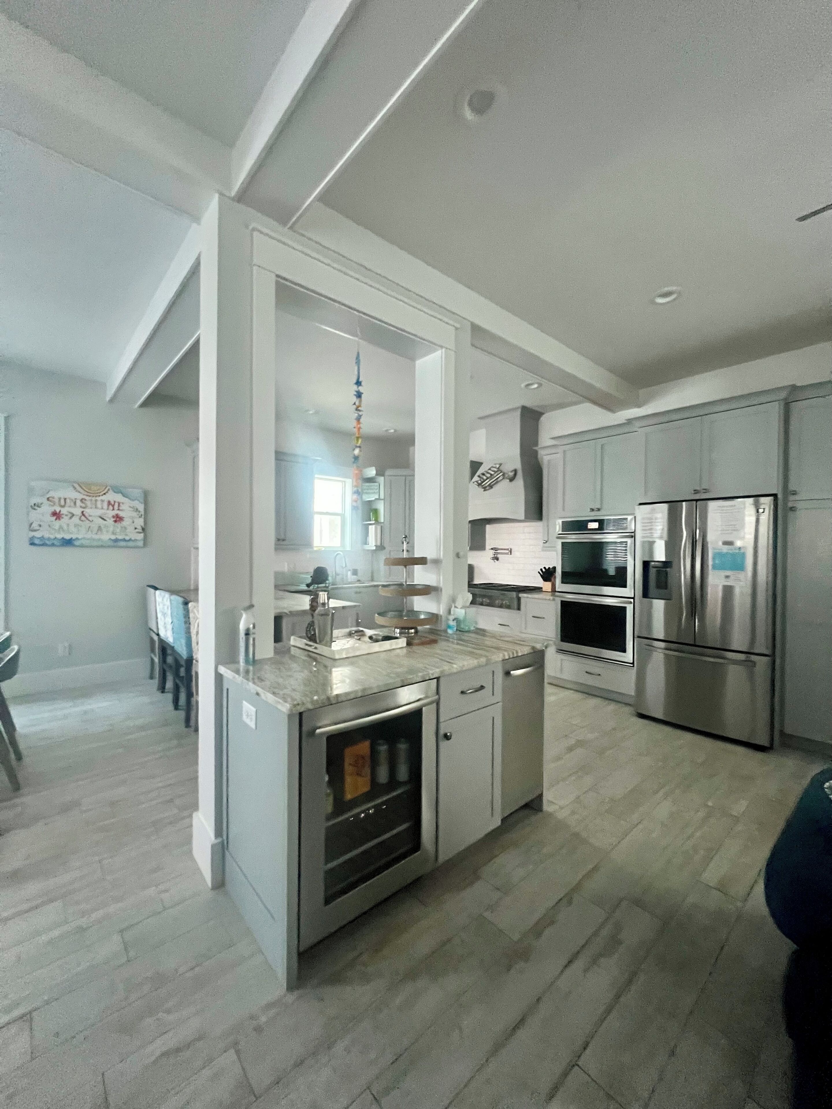 A modern kitchen with stainless steel appliances, a marble countertop, and a central island.