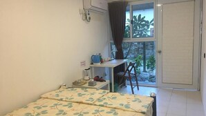 A small bedroom with a bed, a desk, and a window.